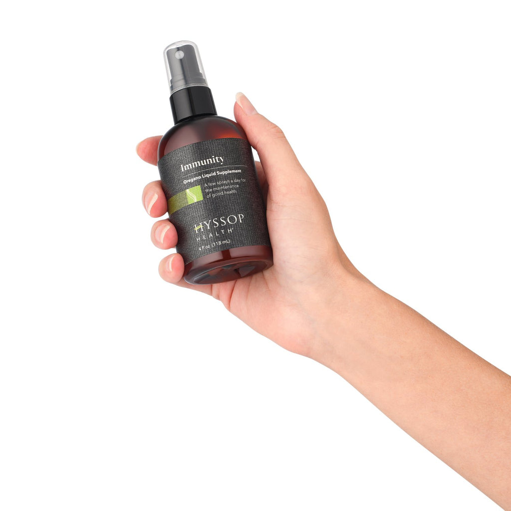 bottle of oregano oil spray being held in someone's hand